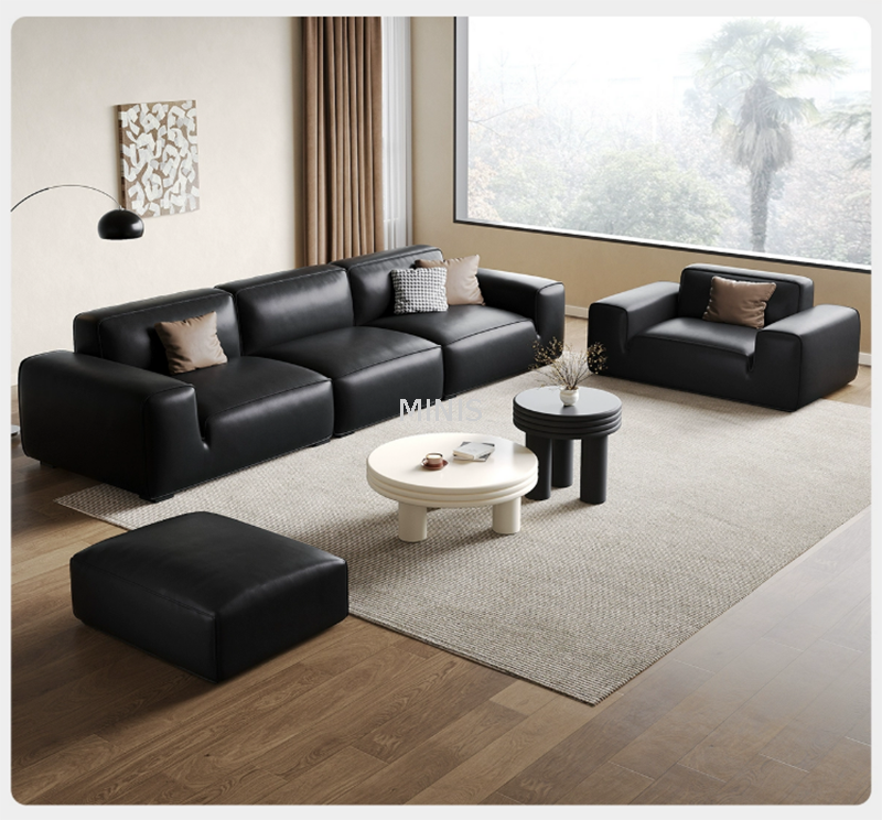 Sofá de cuero negro cómodo agradable de la sala de estar con el otomano